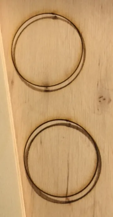 Zwei geschnittene Kreise in Holz, jeweils mit einer zweiten, versetzten Schattenlinie