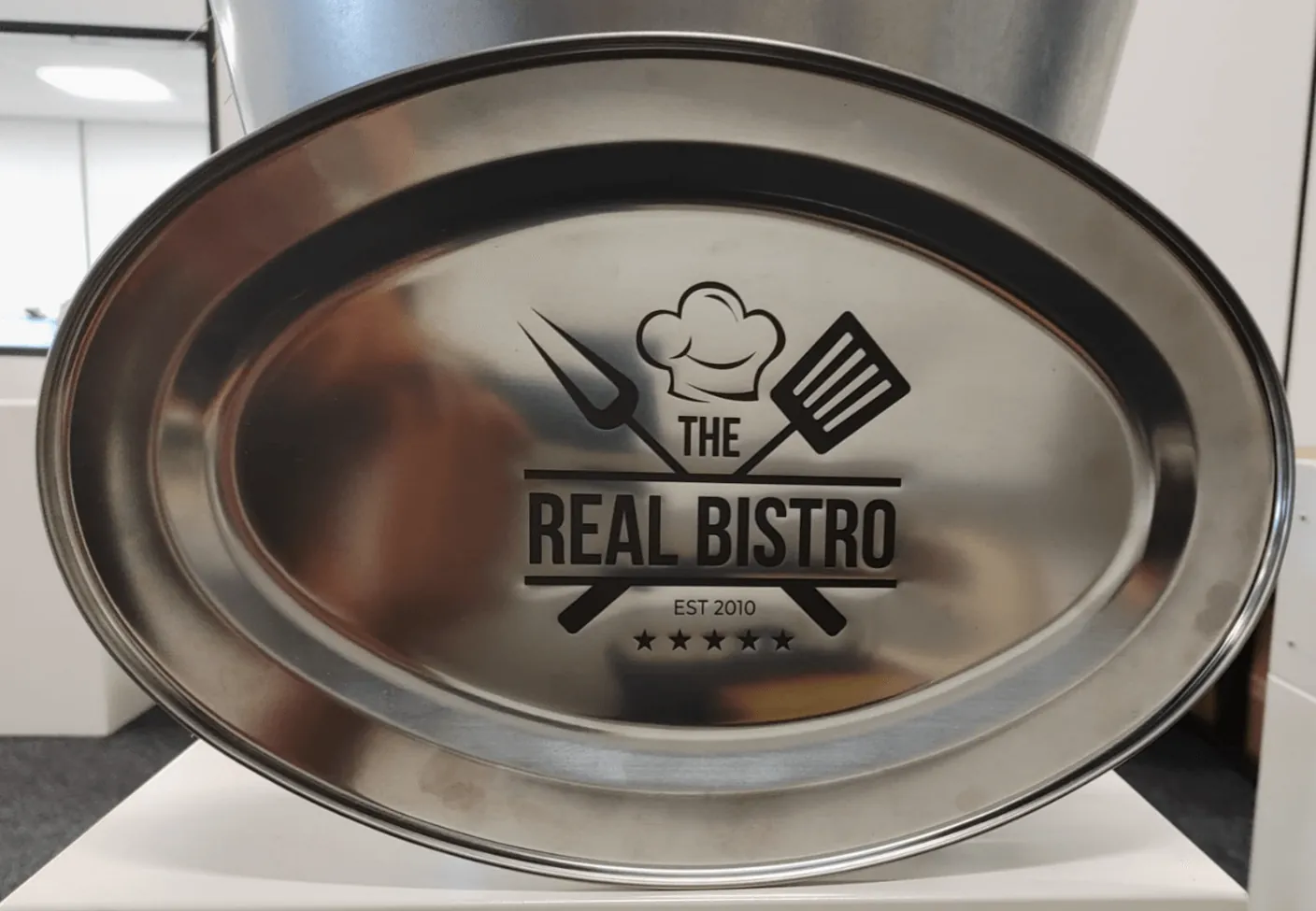 Stainless steel tray with a black logo marked using a laser marking spray