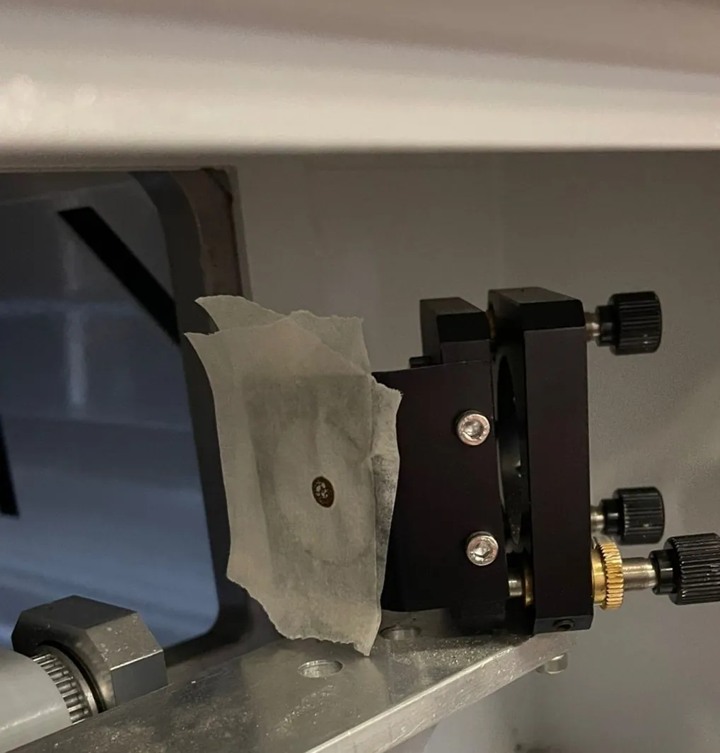 Afplaktape op de tweede spiegelhouder met de brandplek van de testpuls