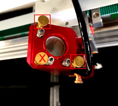 Supporto dello specchio della testa laser con evidenziate le due viti di regolazione da usare e barrata quella da non usare
